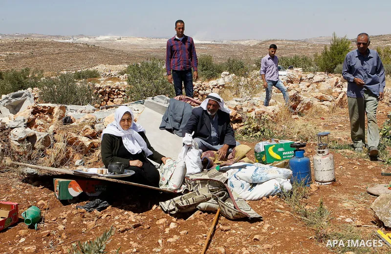 Palestinians check their belongings after Israeli troops demolished their house in the West Bank village of Saeer, near Hebron August 16, 2016. Photo by Wisam Hashlamoun