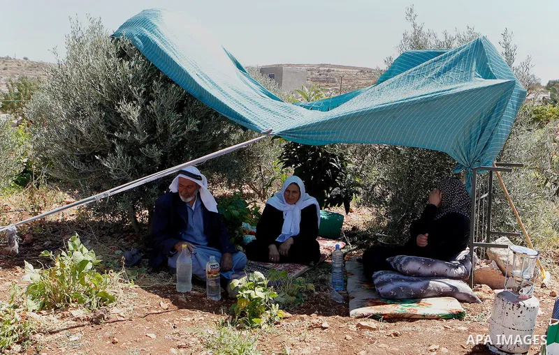 Palestinians sit at a tent after Israeli troops demolished their house in the West Bank village of Saeer, near Hebron August 16, 2016. Photo by Wisam Hashlamoun