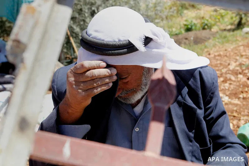 A Palestinian man reacts after Israeli troops demolished his house in the West Bank village of Saeer, near Hebron August 16, 2016. Photo by Wisam Hashlamoun