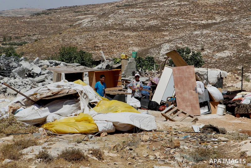 Palestinians check their belongings after Israeli troops demolished their house in the West Bank village of Saeer, near Hebron August 16, 2016. Photo by Wisam Hashlamoun