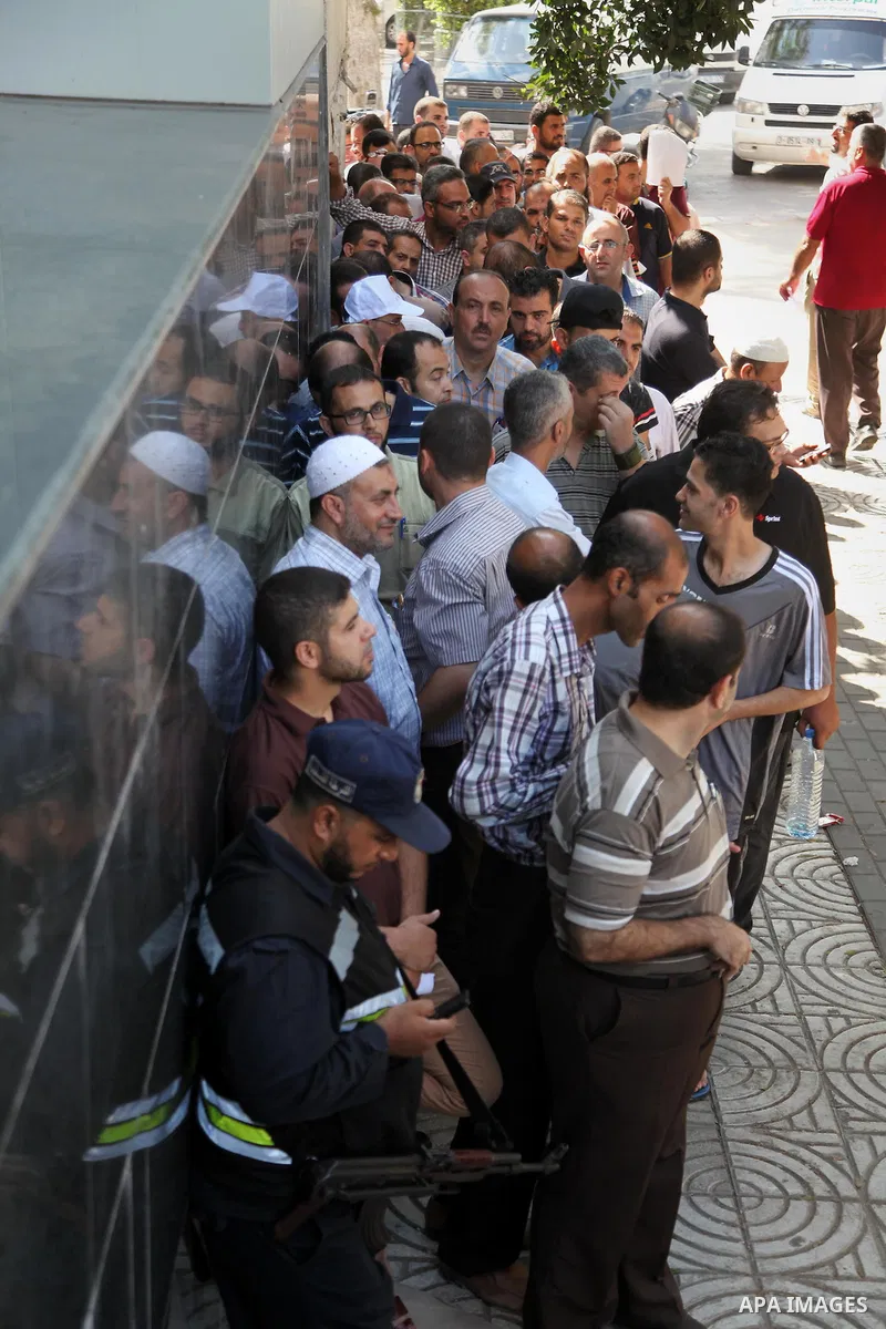 Employees of former Palestinian government in Gaza Strip wait to receive their salaries at a Post Office in Gaza city on August 17, 2016. The Emir of Qatar, Sheikh Tamim bin Hamad al-Thani, has ordered paying a total of...