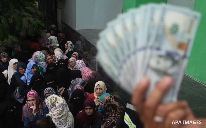 Employees of former Palestinian government in Gaza Strip wait to receive their salaries at a Post Office in Gaza city on August 17, 2016. The Emir of Qatar, Sheikh Tamim bin Hamad al-Thani, has ordered paying a total of...