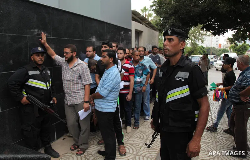 Employees of former Palestinian government in Gaza Strip wait to receive their salaries at a Post Office in Gaza city on August 17, 2016. The Emir of Qatar, Sheikh Tamim bin Hamad al-Thani, has ordered paying a total of...