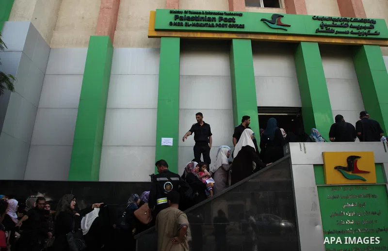 Employees of former Palestinian government in Gaza Strip wait to receive their salaries at a Post Office in Gaza city on August 17, 2016. The Emir of Qatar, Sheikh Tamim bin Hamad al-Thani, has ordered paying a total of...