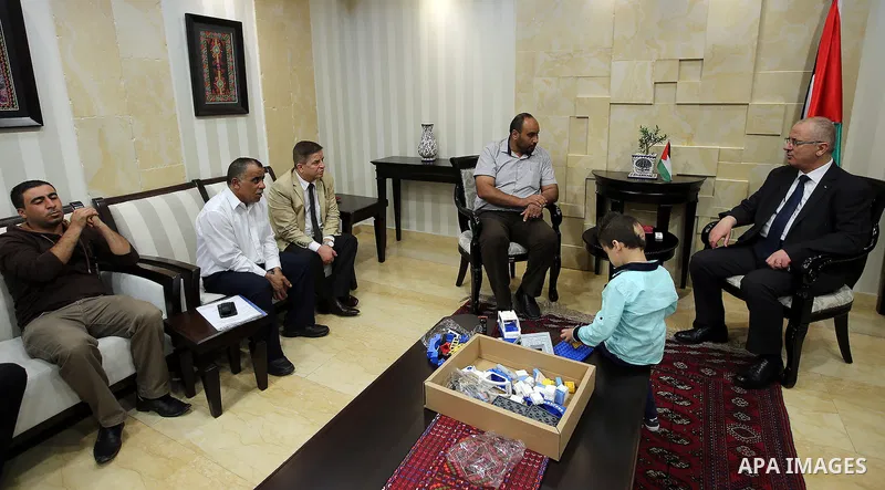 Palestinian Prime Minister, Rami Hamdallah meets with Ahmed Dawabsha, who suffered severe burns in an arson attack by suspected Jewish attackers on his family home last year in which his younger brother, Ali, and his par...