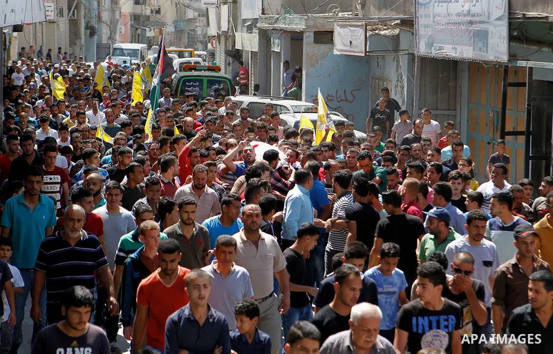 Mourners carry the body of Palestinian Mohammed Abu Hashash, who was shot dead during clashes with Israeli forces the day before, during his funeral on August 17, 2016 in the al-Fawwar Palestinian refugee camp, south of...