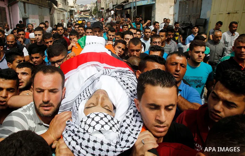 Mourners carry the body of Palestinian Mohammed Abu Hashash, who was shot dead during clashes with Israeli forces the day before, during his funeral on August 17, 2016 in the al-Fawwar Palestinian refugee camp, south of...