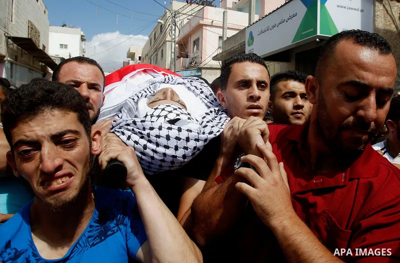 Mourners carry the body of Palestinian Mohammed Abu Hashash, who was shot dead during clashes with Israeli forces the day before, during his funeral on August 17, 2016 in the al-Fawwar Palestinian refugee camp, south of...