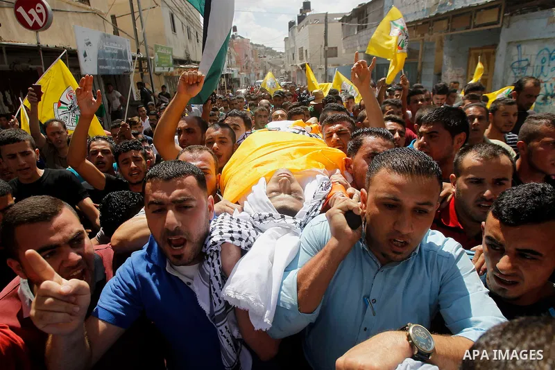 Mourners carry the body of Palestinian Mohammed Abu Hashash, who was shot dead during clashes with Israeli forces the day before, during his funeral on August 17, 2016 in the al-Fawwar Palestinian refugee camp, south of...