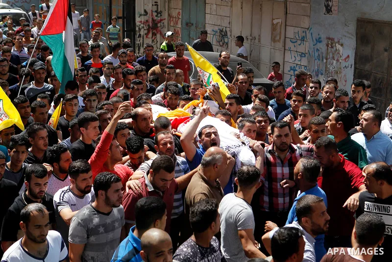 Mourners carry the body of Palestinian Mohammed Abu Hashash, who was shot dead during clashes with Israeli forces the day before, during his funeral on August 17, 2016 in the al-Fawwar Palestinian refugee camp, south of...