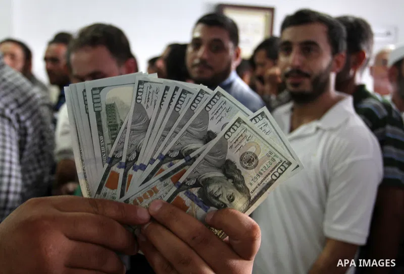 Employees of former Palestinian government in Gaza Strip wait to receive their salaries at a Post Office in Rafah in the southern Gaza strip on August 17, 2016. The Emir of Qatar, Sheikh Tamim bin Hamad al-Thani, has ord...