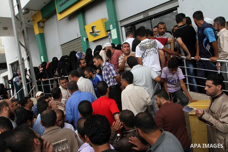 Employees of former Palestinian government in Gaza Strip wait to receive their salaries at a Post Office in Rafah in the southern Gaza strip on August 17, 2016. The Emir of Qatar, Sheikh Tamim bin Hamad al-Thani, has ord...