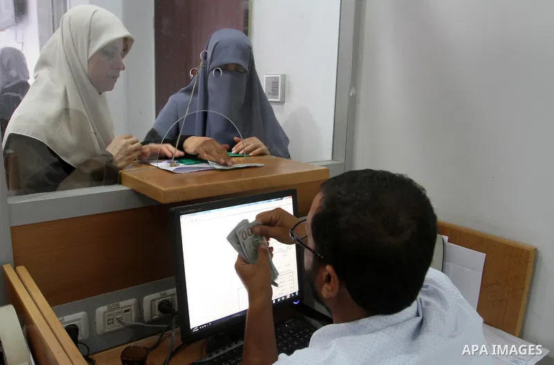 Employees of former Palestinian government in Gaza Strip wait to receive their salaries at a Post Office in Rafah in the southern Gaza strip on August 17, 2016. The Emir of Qatar, Sheikh Tamim bin Hamad al-Thani, has ord...