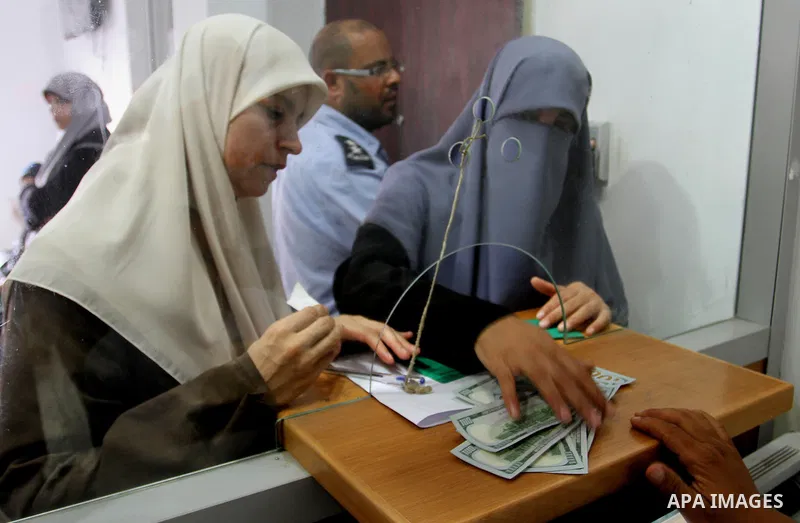 Employees of former Palestinian government in Gaza Strip wait to receive their salaries at a Post Office in Rafah in the southern Gaza strip on August 17, 2016. The Emir of Qatar, Sheikh Tamim bin Hamad al-Thani, has ord...