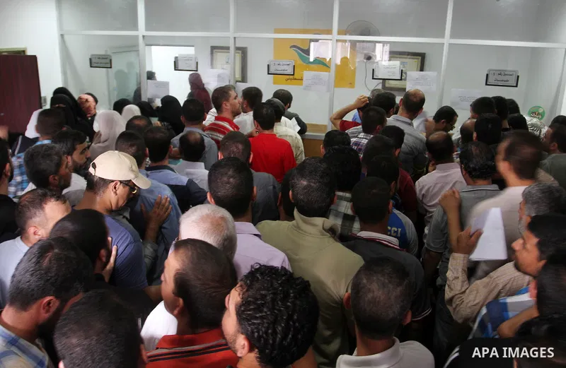 Employees of former Palestinian government in Gaza Strip wait to receive their salaries at a Post Office in Rafah in the southern Gaza strip on August 17, 2016. The Emir of Qatar, Sheikh Tamim bin Hamad al-Thani, has ord...
