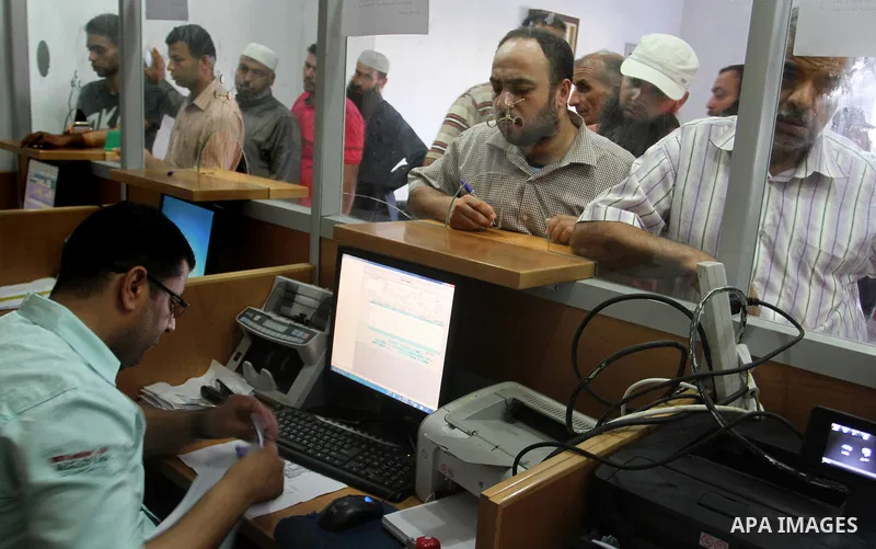 Employees of former Palestinian government in Gaza Strip wait to receive their salaries at a Post Office in Rafah in the southern Gaza strip on August 17, 2016. The Emir of Qatar, Sheikh Tamim bin Hamad al-Thani, has ord...