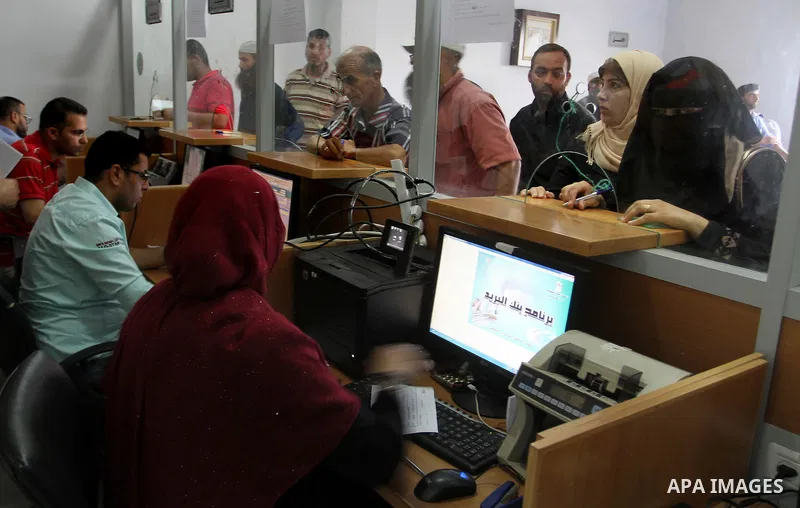 Employees of former Palestinian government in Gaza Strip wait to receive their salaries at a Post Office in Rafah in the southern Gaza strip on August 17, 2016. The Emir of Qatar, Sheikh Tamim bin Hamad al-Thani, has ord...