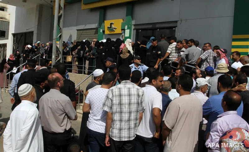 Employees of former Palestinian government in Gaza Strip wait to receive their salaries at a Post Office in Rafah in the southern Gaza strip on August 17, 2016. The Emir of Qatar, Sheikh Tamim bin Hamad al-Thani, has ord...