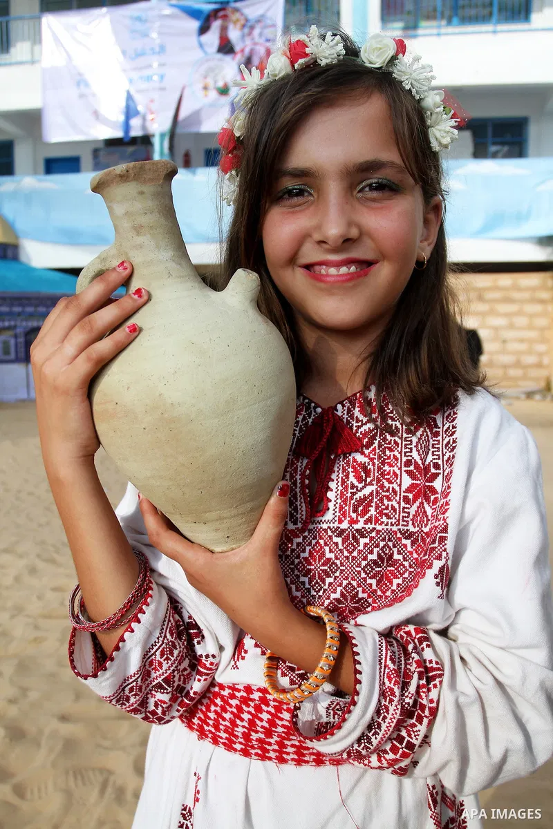Palestinians take part in heritage festival during the closing ceremony of 2016 summer fun week organised by the United Nations Relief and Works Agency (UNRWA), in Khan Younis in the southern Gaza strip, on August 17, 20...