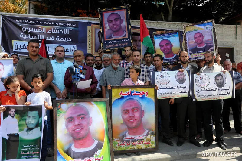 Palestinians hold posters for four men abducted by unidentified masked gunmen on August 19 during a protest demanding for their return, in front of Red Cross office, in August 18, 2016. Photo by Mohammed Asad