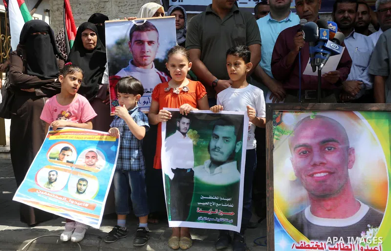 Palestinians hold posters for four men abducted by unidentified masked gunmen on August 19 during a protest demanding for their return, in front of Red Cross office, in August 18, 2016. Photo by Mohammed Asad
