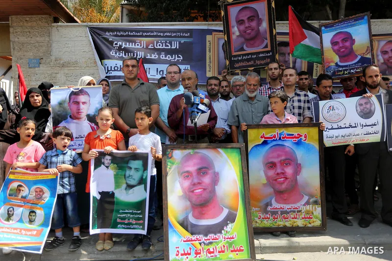 Palestinians hold posters for four men abducted by unidentified masked gunmen on August 19 during a protest demanding for their return, in front of Red Cross office, in August 18, 2016. Photo by Mohammed Asad