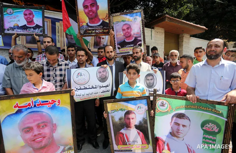 Palestinians hold posters for four men abducted by unidentified masked gunmen on August 19 during a protest demanding for their return, in front of Red Cross office, in August 18, 2016. Photo by Mohammed Asad