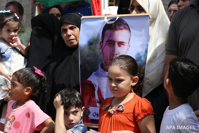 Palestinians hold posters for four men abducted by unidentified masked gunmen on August 19 during a protest demanding for their return, in front of Red Cross office, in August 18, 2016. Photo by Mohammed Asad