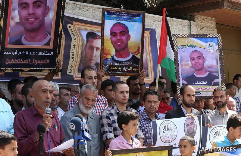 Palestinians hold posters for four men abducted by unidentified masked gunmen on August 19 during a protest demanding for their return, in front of Red Cross office, in August 18, 2016. Photo by Mohammed Asad