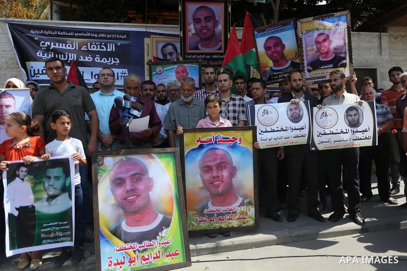 Palestinians hold posters for four men abducted by unidentified masked gunmen on August 19 during a protest demanding for their return, in front of Red Cross office, in August 18, 2016. Photo by Mohammed Asad