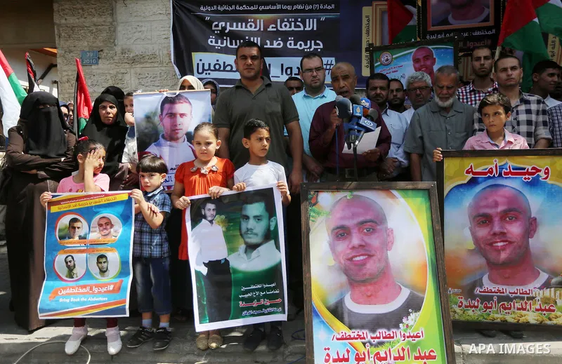 Palestinians hold posters for four men abducted by unidentified masked gunmen on August 19 during a protest demanding for their return, in front of Red Cross office, in August 18, 2016. Photo by Mohammed Asad