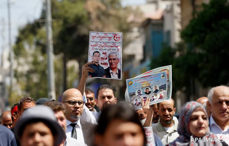 Palestinians hold posters against administrative detention and in support of Palestinian prisoner Bilal Kayed (portrait), who has been fasting for almost two months over his detention without trial, in the West Bank city...