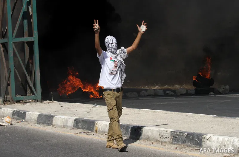 A Palestinian protester reacts during clashes with Israeli troops following a protest in solidarity with Palestinian prisoners held in Israeli jails, at the Hawara checkpoint near the West Bank city of Nablus on Aug. 18,...