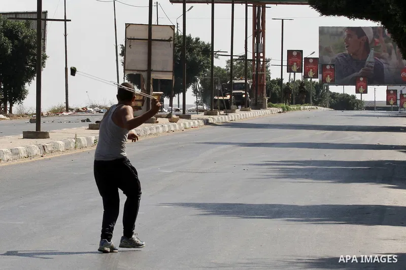 A Palestinian protester hurls stones towards Israeli troops during clashes following a protest in solidarity with Palestinian prisoners held in Israeli jails, at the Hawara checkpoint near the West Bank city of Nablus on...