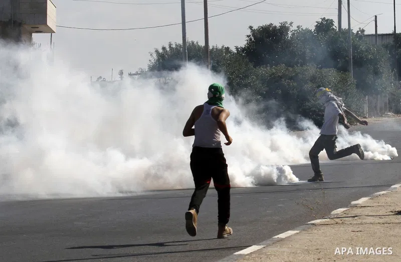 A Palestinian protester kicks a tear gas canister fired by Israeli troops during clashes following a protest in solidarity with Palestinian prisoners held in Israeli jails, at the Hawara checkpoint near the West Bank cit...