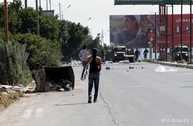 A Palestinian protester hurls stones towards Israeli troops during clashes following a protest in solidarity with Palestinian prisoners held in Israeli jails, at the Hawara checkpoint near the West Bank city of Nablus on...