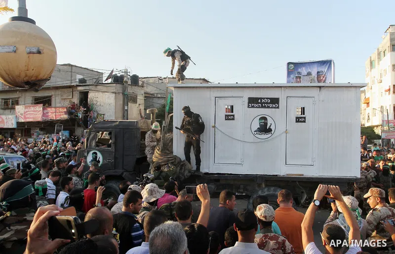 A Palestinian member of al-Qassam Brigades, the armed wing of the Hamas movement, stands guard in front of a mock jail for Israeli soldiers during an anti-Israel military parade, in Rafah in the southern Gaza Strip Augus...