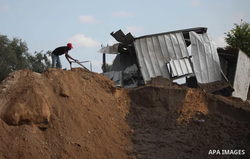 Palestinian security men arrive to inspect a crater on August 22, 2016 in Beit Lahia in the northern Gaza Strip, following an Israeli airstrike the day before that targeted Hamas positions in the Gaza Strip in response t...