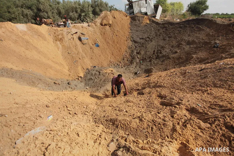 Palestinian security men arrive to inspect a crater on August 22, 2016 in Beit Lahia in the northern Gaza Strip, following an Israeli airstrike the day before that targeted Hamas positions in the Gaza Strip in response t...