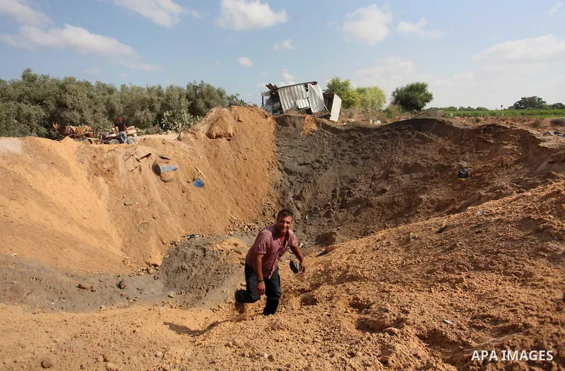 Palestinian security men arrive to inspect a crater on August 22, 2016 in Beit Lahia in the northern Gaza Strip, following an Israeli airstrike the day before that targeted Hamas positions in the Gaza Strip in response t...
