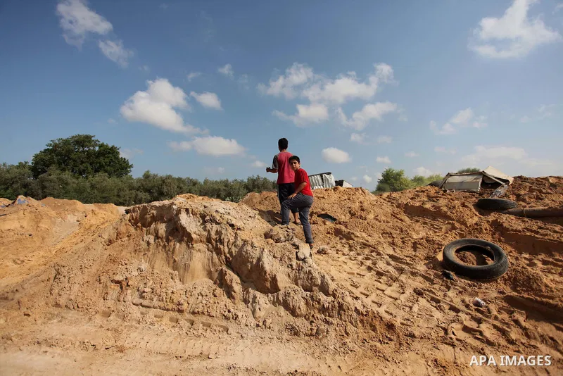 Palestinian security men arrive to inspect a crater on August 22, 2016 in Beit Lahia in the northern Gaza Strip, following an Israeli airstrike the day before that targeted Hamas positions in the Gaza Strip in response t...