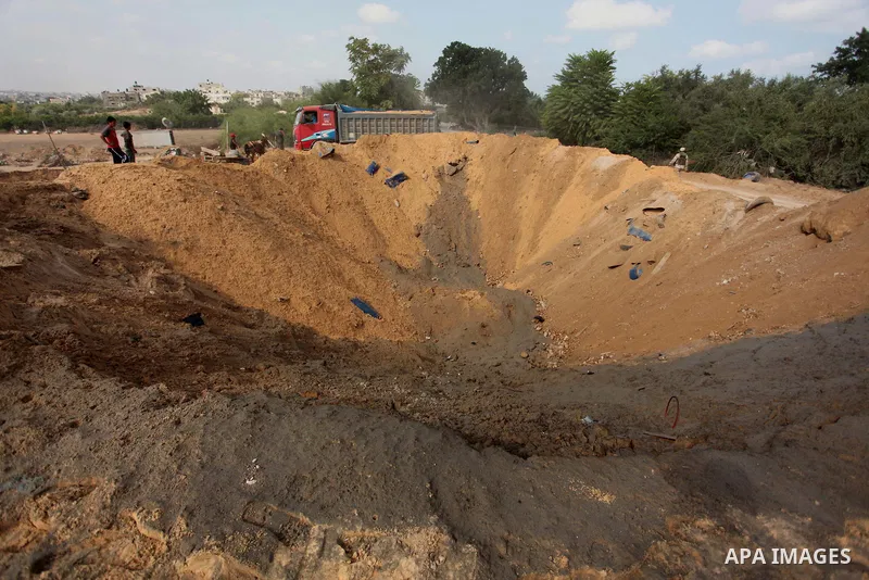 Palestinian security men arrive to inspect a crater on August 22, 2016 in Beit Lahia in the northern Gaza Strip, following an Israeli airstrike the day before that targeted Hamas positions in the Gaza Strip in response t...