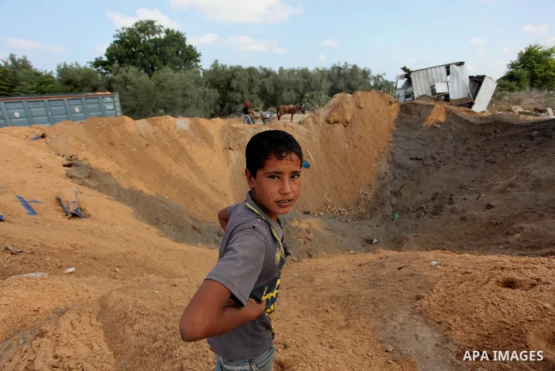 Palestinian security men arrive to inspect a crater on August 22, 2016 in Beit Lahia in the northern Gaza Strip, following an Israeli airstrike the day before that targeted Hamas positions in the Gaza Strip in response t...