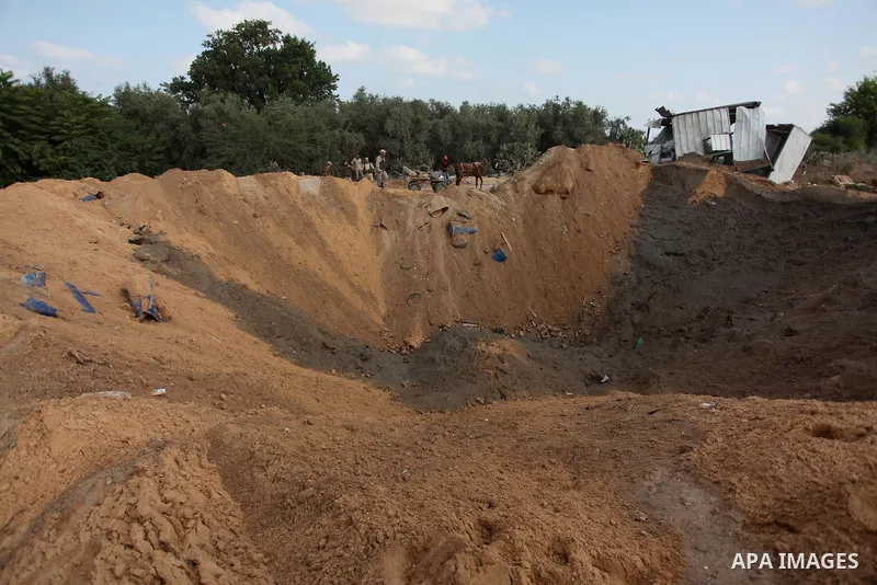 Palestinian security men arrive to inspect a crater on August 22, 2016 in Beit Lahia in the northern Gaza Strip, following an Israeli airstrike the day before that targeted Hamas positions in the Gaza Strip in response t...