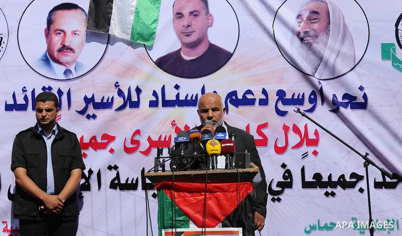 Palestinians hold posters against administrative detention and in support of Palestinian prisoner Bilal Kayed (portrait), who has been fasting for almost two months over his detention without trial, in front of Red Cross...