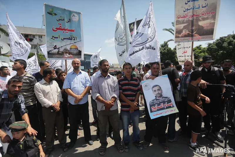Palestinians hold posters against administrative detention and in support of Palestinian prisoner Bilal Kayed, who has been fasting for almost two months over his detention without trial, in Gaza city on Aug. 23, 2016. P...