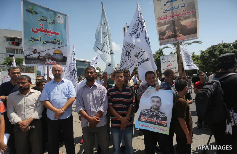 Palestinians hold posters against administrative detention and in support of Palestinian prisoner Bilal Kayed, who has been fasting for almost two months over his detention without trial, in Gaza city on Aug. 23, 2016. P...