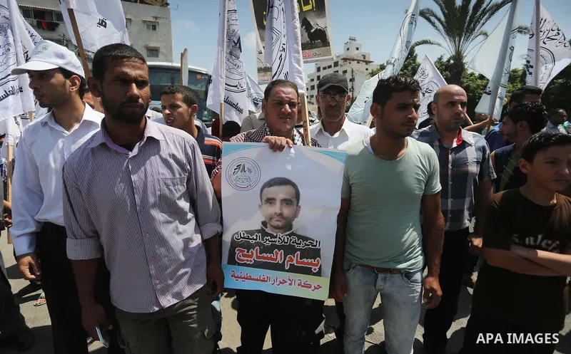 Palestinians hold posters against administrative detention and in support of Palestinian prisoner Bilal Kayed, who has been fasting for almost two months over his detention without trial, in Gaza city on Aug. 23, 2016. P...