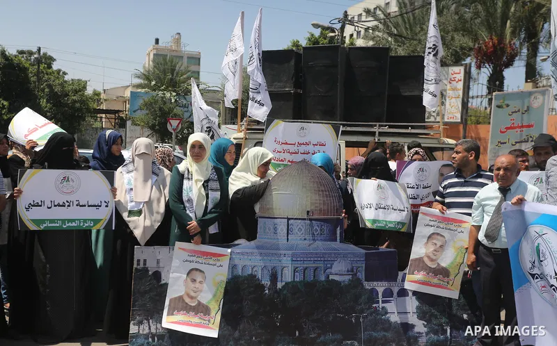 Palestinians hold posters against administrative detention and in support of Palestinian prisoner Bilal Kayed, who has been fasting for almost two months over his detention without trial, in Gaza city on Aug. 23, 2016. P...