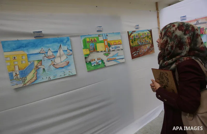 Palestinians attend the art exhibition "draw your dream for Gaza 2020", in Gaza city on Aug. 23, 2016. Photo by Mohammed Asad